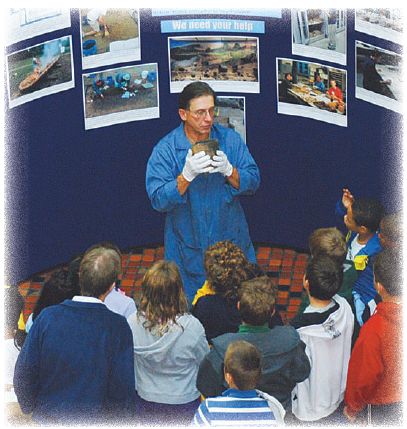 Archaeologist Jim Herbstritt displays a ceramic pot to students.