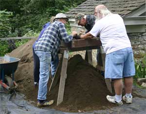 Volunteers screen dirt at a site
