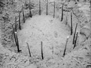 Sticks placed in palisade postholes covered by snow at Troutman