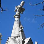 Finial threathened by growing tree branches.