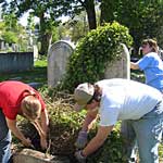 Volunteers clean and repair cradle grave. 